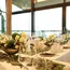 Eleganter festlich gedeckter Tisch mit Blumenarrangements und Kerzen am Fenster