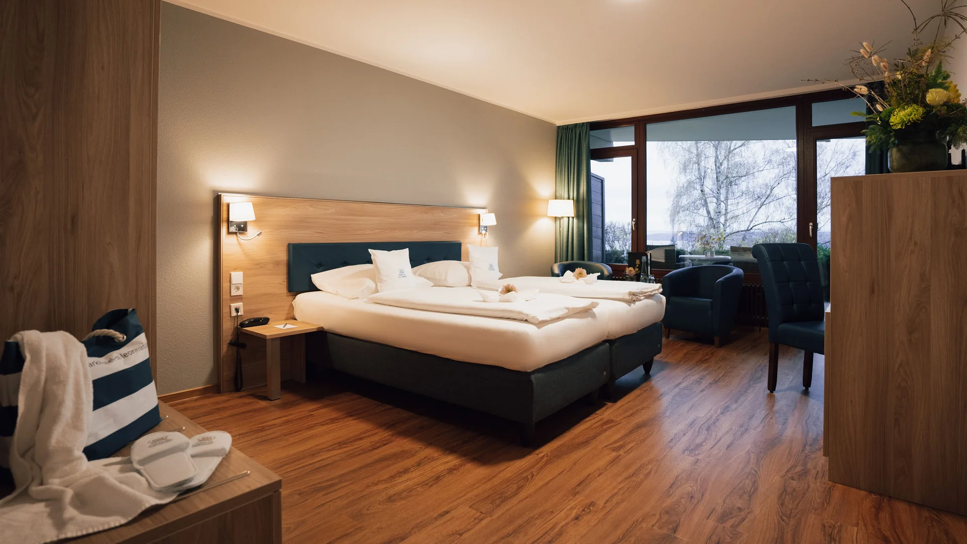 Gemütliches Hotelzimmer mit Doppelbett, Sesseln und großem Fenster mit Ausblick